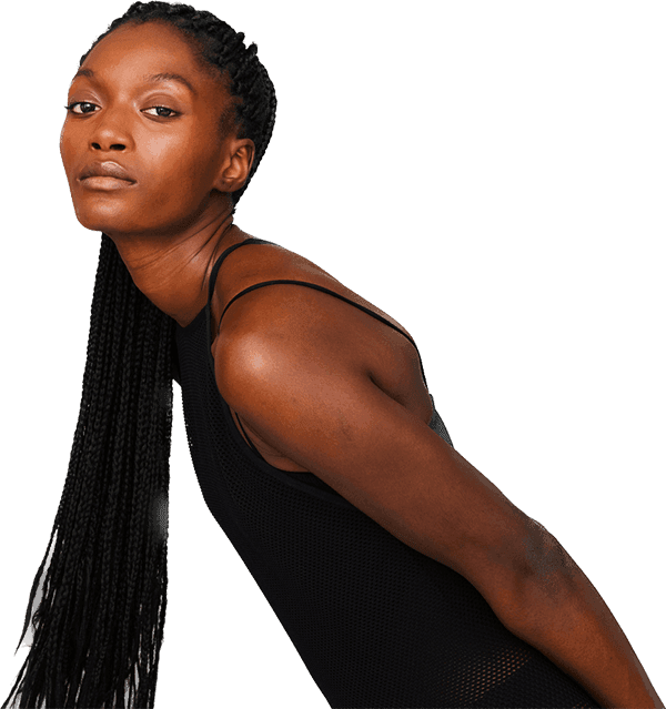 Young black woman with long braided hair leaning forward and looking at camera expressionless