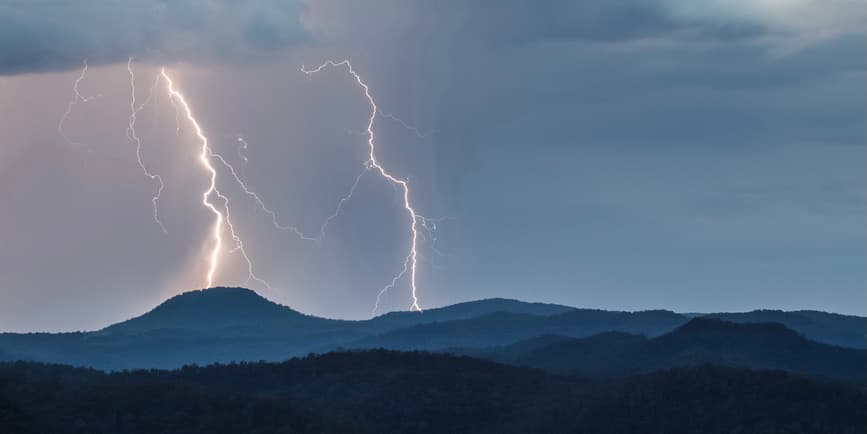 Lightening on mountain Looking over the Wollombi valley towards the Watagan mountains with Mount Warrawolong taking a direct hit of lightning, New South Wales, Australia.