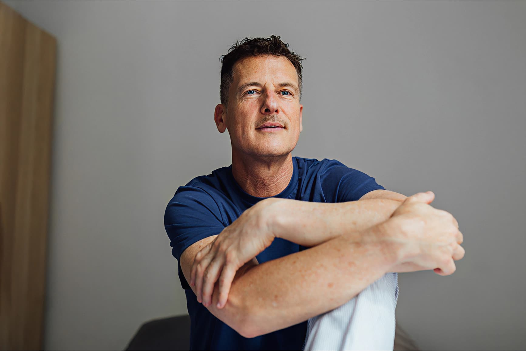 Male sitting with arms on chair